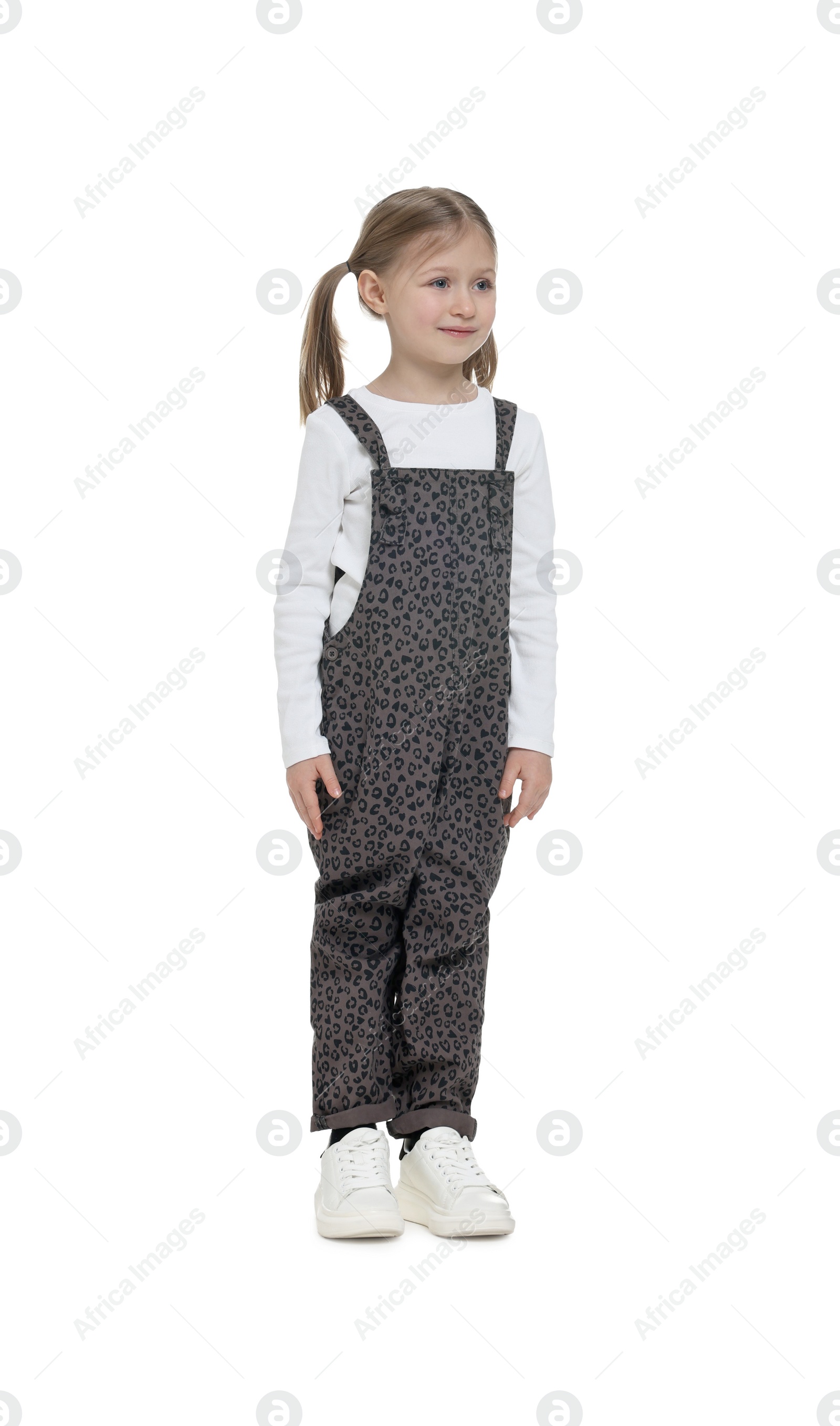 Photo of Cute girl in stylish overall on white background