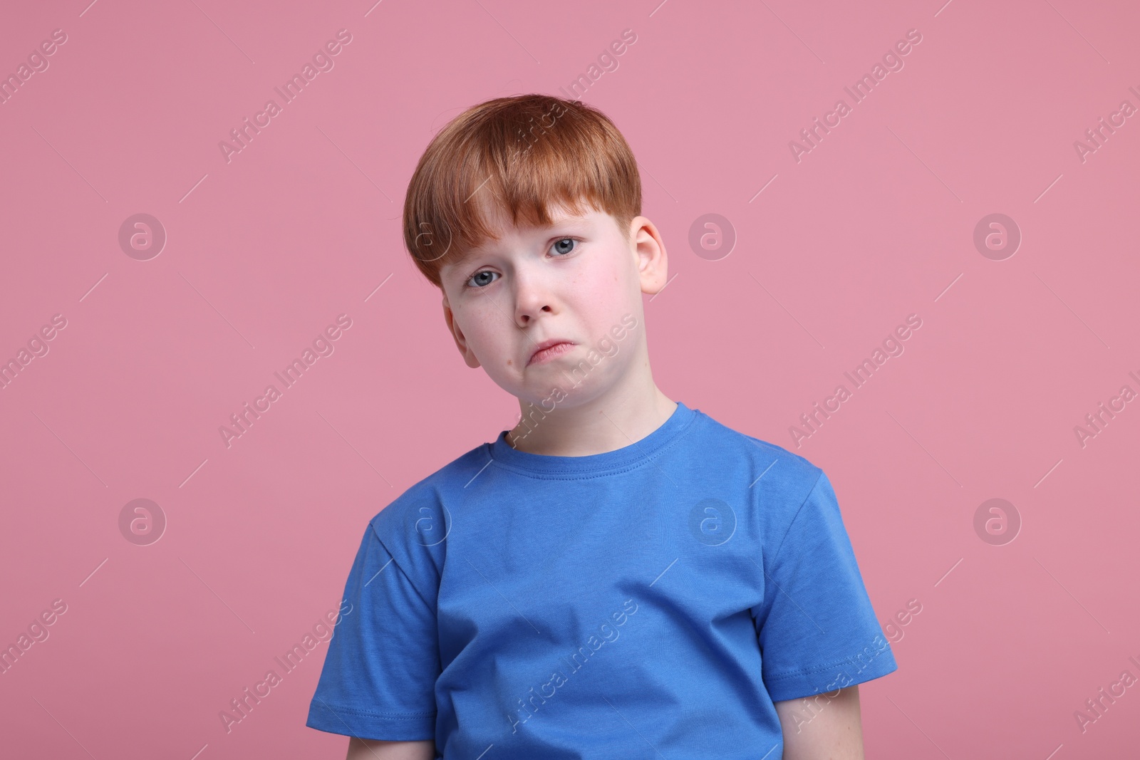 Photo of Portrait of sad little boy on pink background