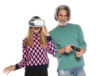 Photo of Teenage girl wearing VR headset and mature man with controller playing video games on white background