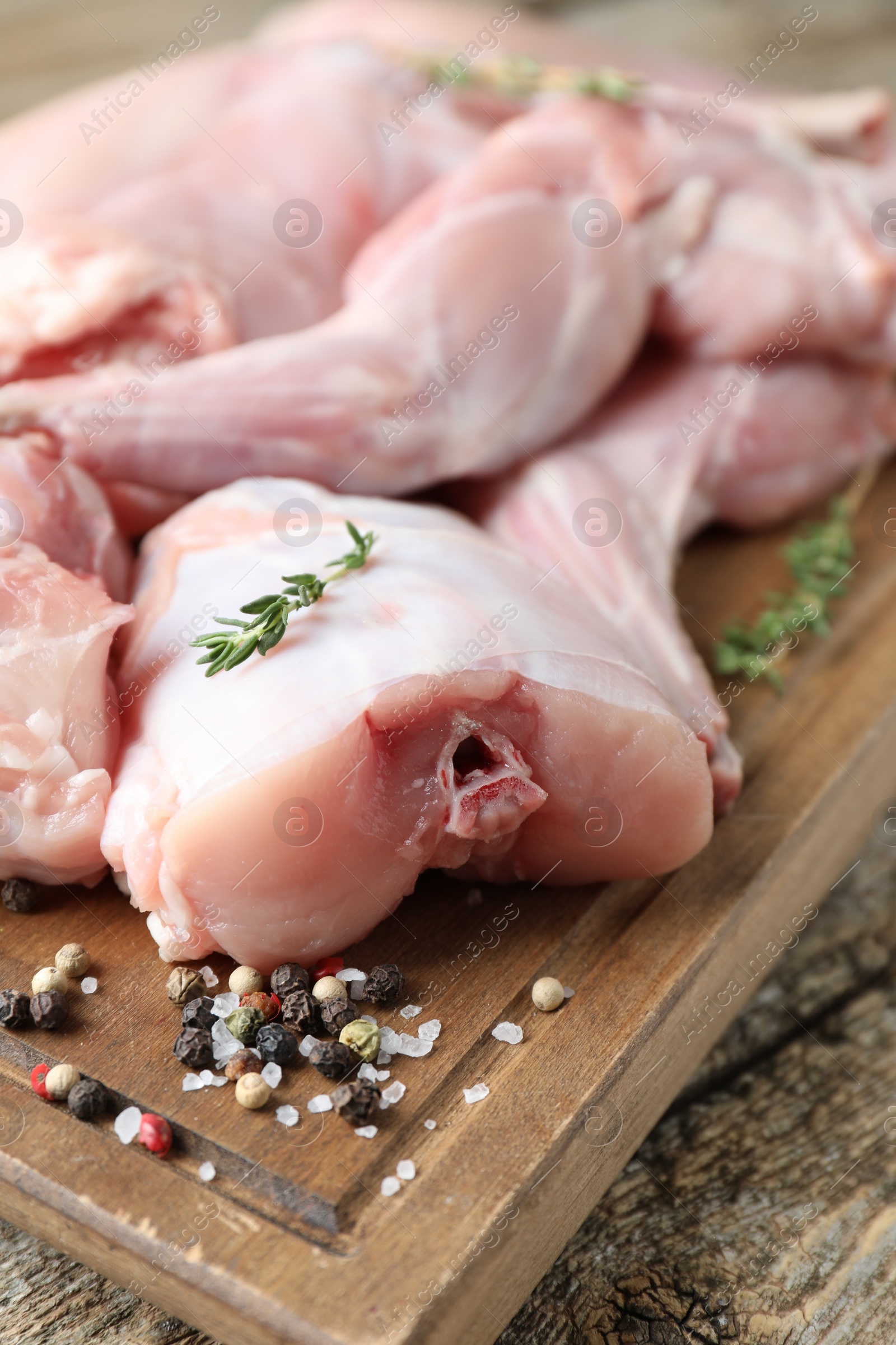 Photo of Fresh raw rabbit meat and spices on wooden table, closeup