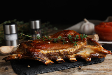 Photo of Delicious roasted ribs served on wooden table