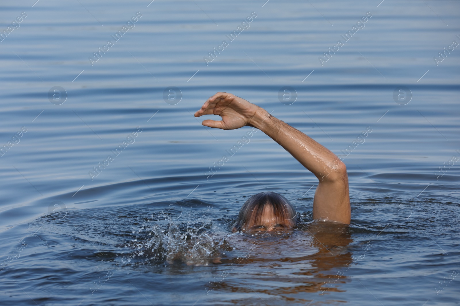 Photo of Drowning man reaching for help in sea, closeup