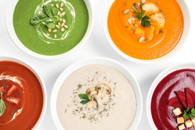 Various soups in bowls on white background, top view. Healthy food