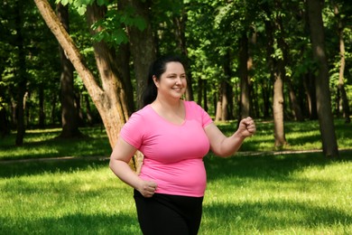 Photo of Happy overweight woman doing exercise in park