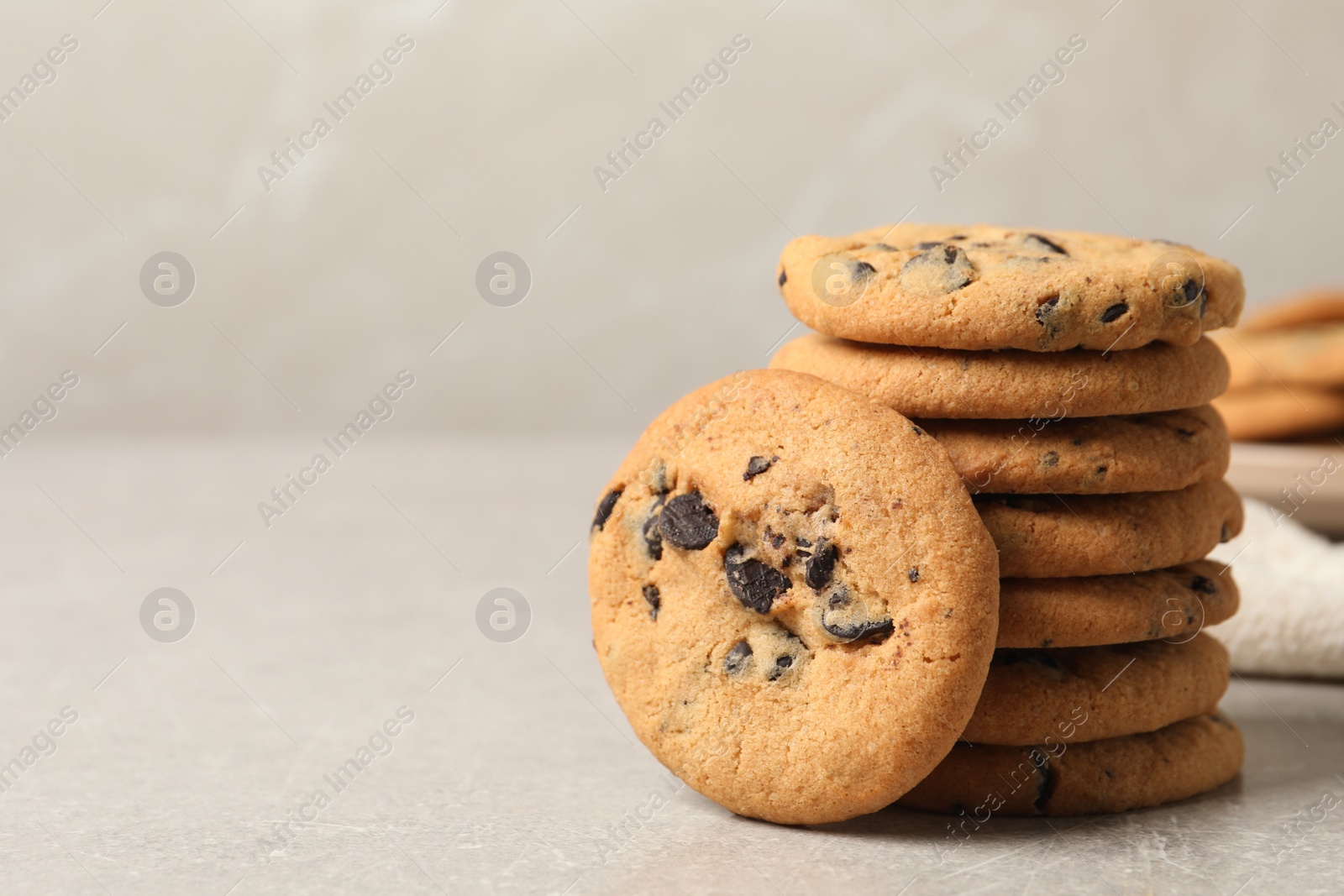 Photo of Tasty chocolate chip cookies on grey table. Space for text