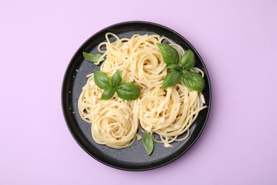 Photo of Delicious pasta with brie cheese and basil leaves on violet background, top view