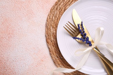 Photo of Cutlery, plate and preserved lavender flowers on color textured table, top view. Space for text