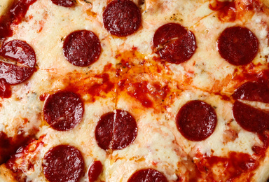 Photo of Hot delicious pepperoni pizza with melted cheese, closeup