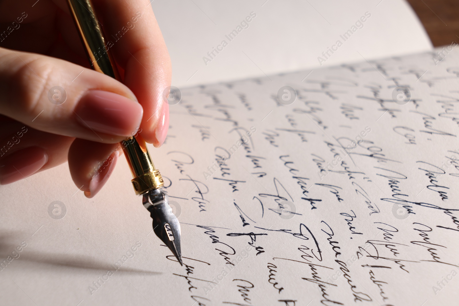 Photo of Woman writing with fountain pen in notebook, closeup