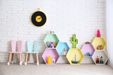 Child room interior with colorful shelves near brick wall