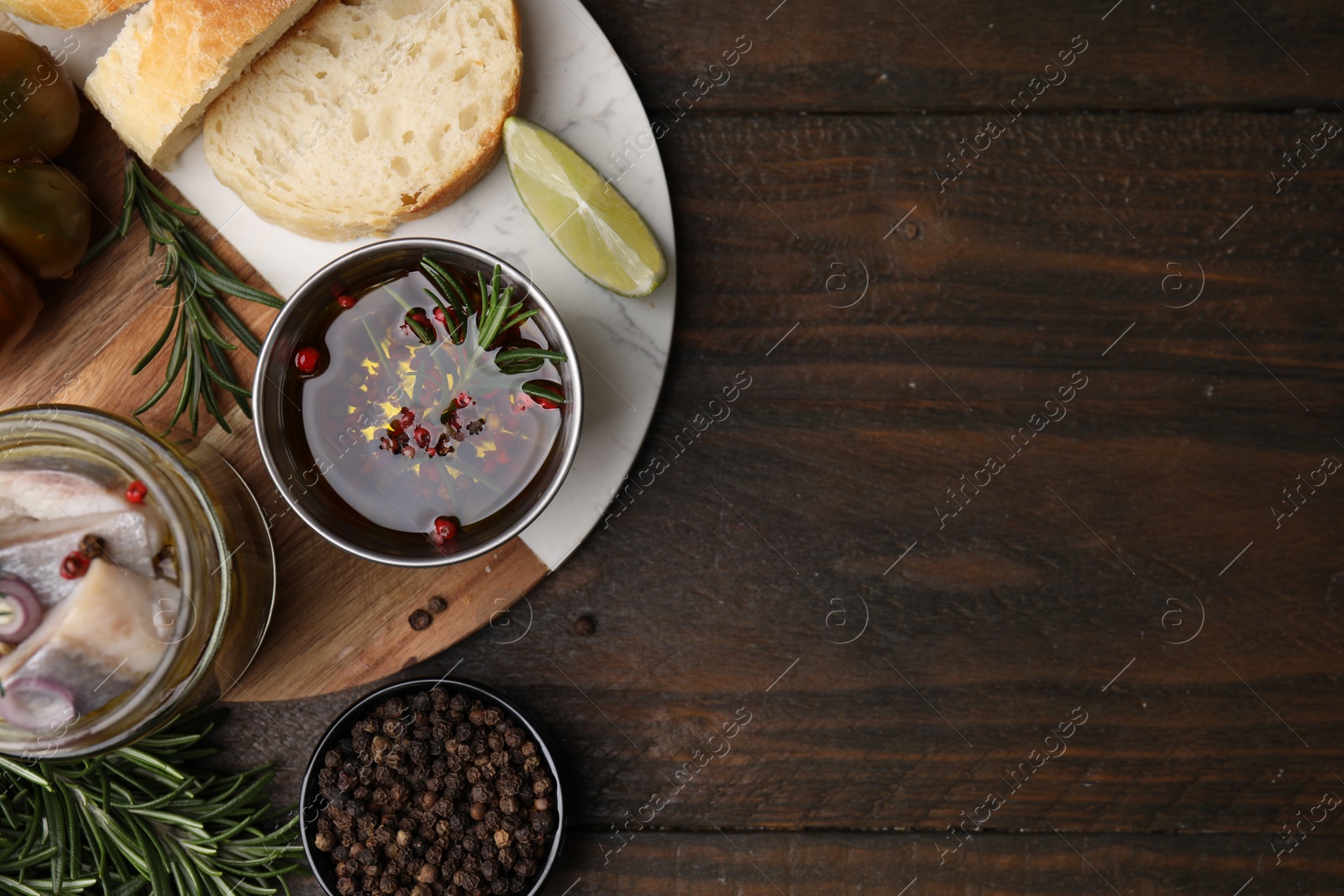 Photo of Tasty fish marinade with rosemary in bowl and products on wooden table, flat lay. Space for text