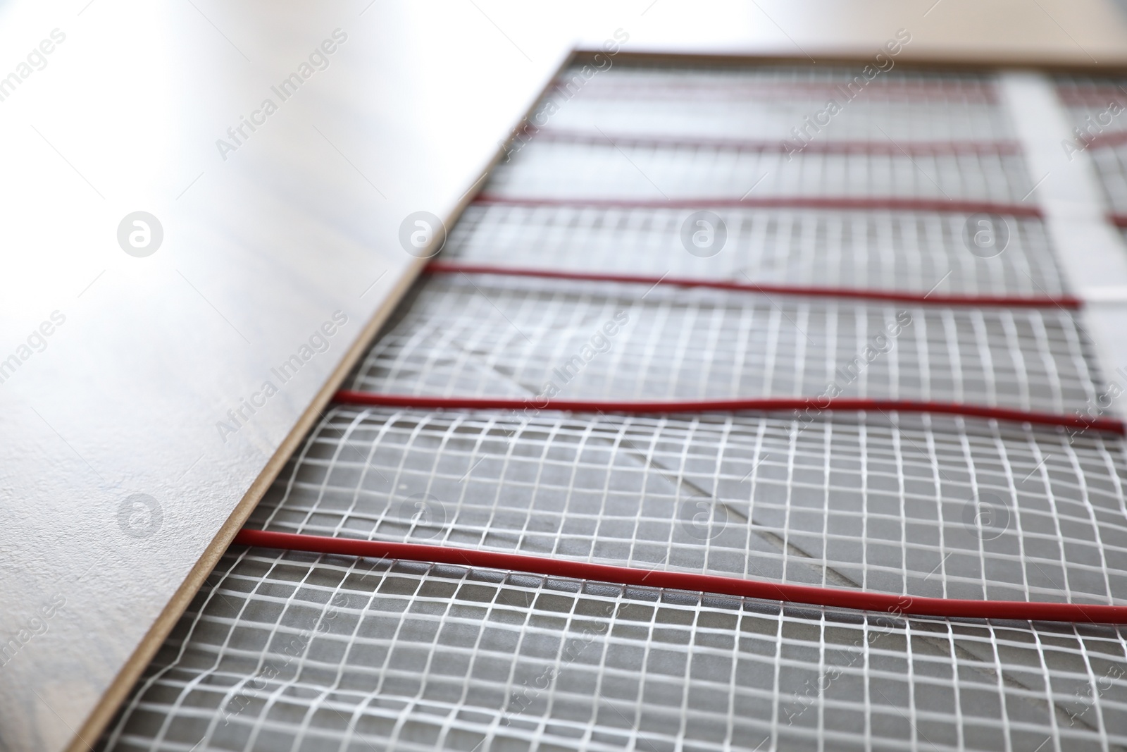 Photo of Installation of modern underfloor trace heating system indoors, closeup