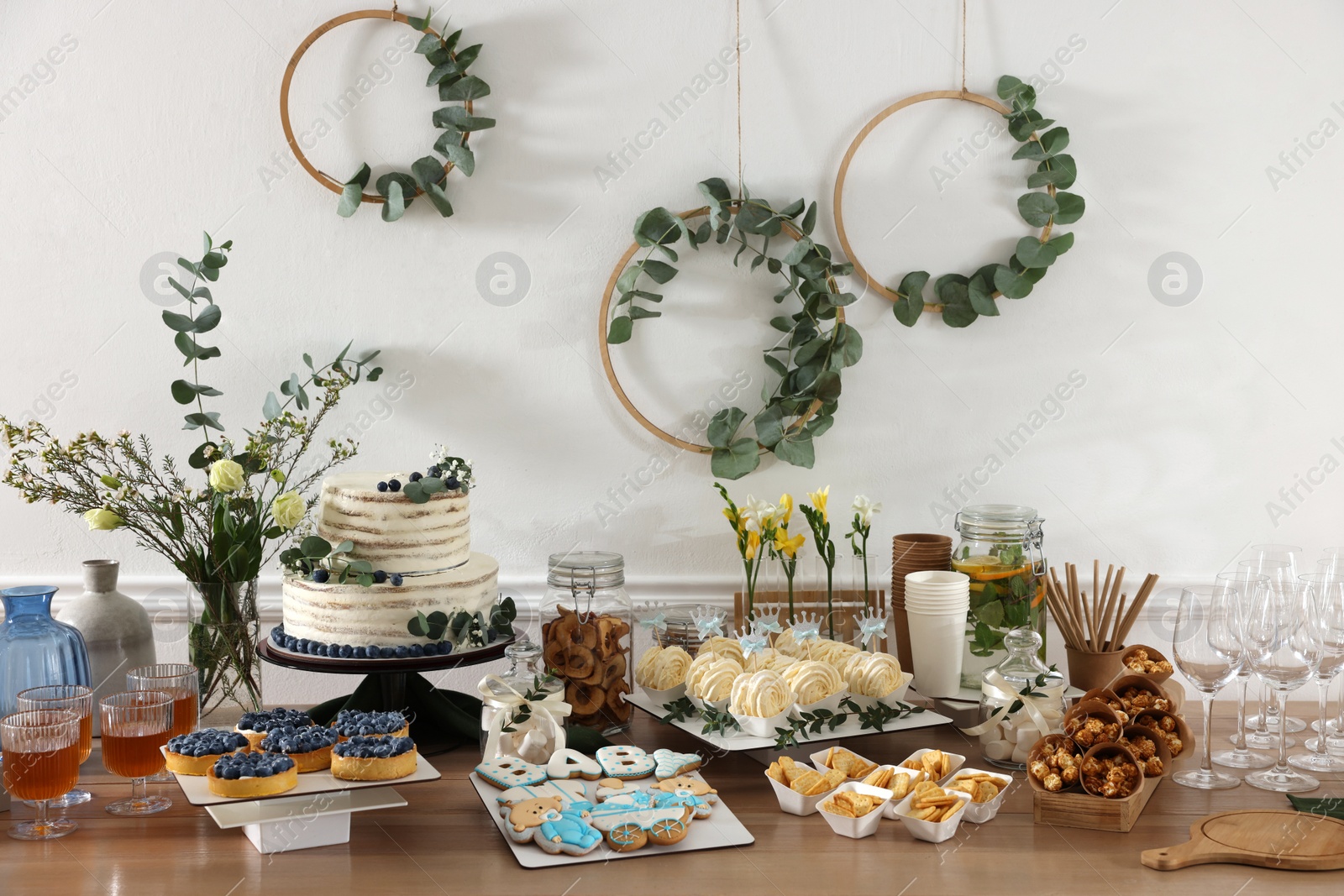 Photo of Beautiful cake and other treats on table in room. Baby shower party