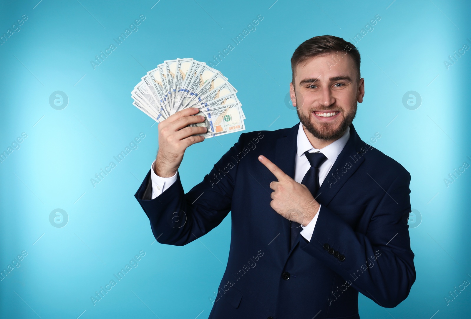 Photo of Portrait of happy young businessman with money on color background