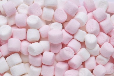 Photo of Delicious puffy pink and white marshmallows as background, top view