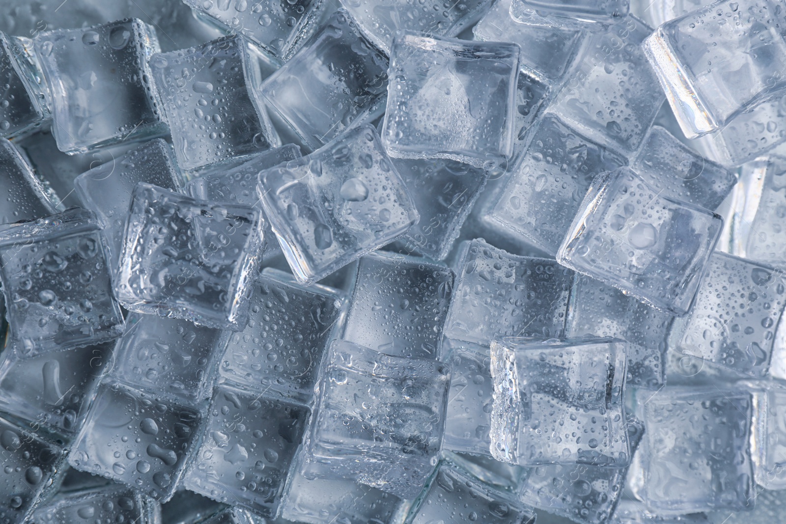 Photo of Crystal clear ice cubes with water drops as background, top view