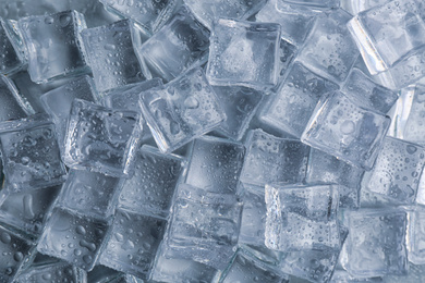 Crystal clear ice cubes with water drops as background, top view