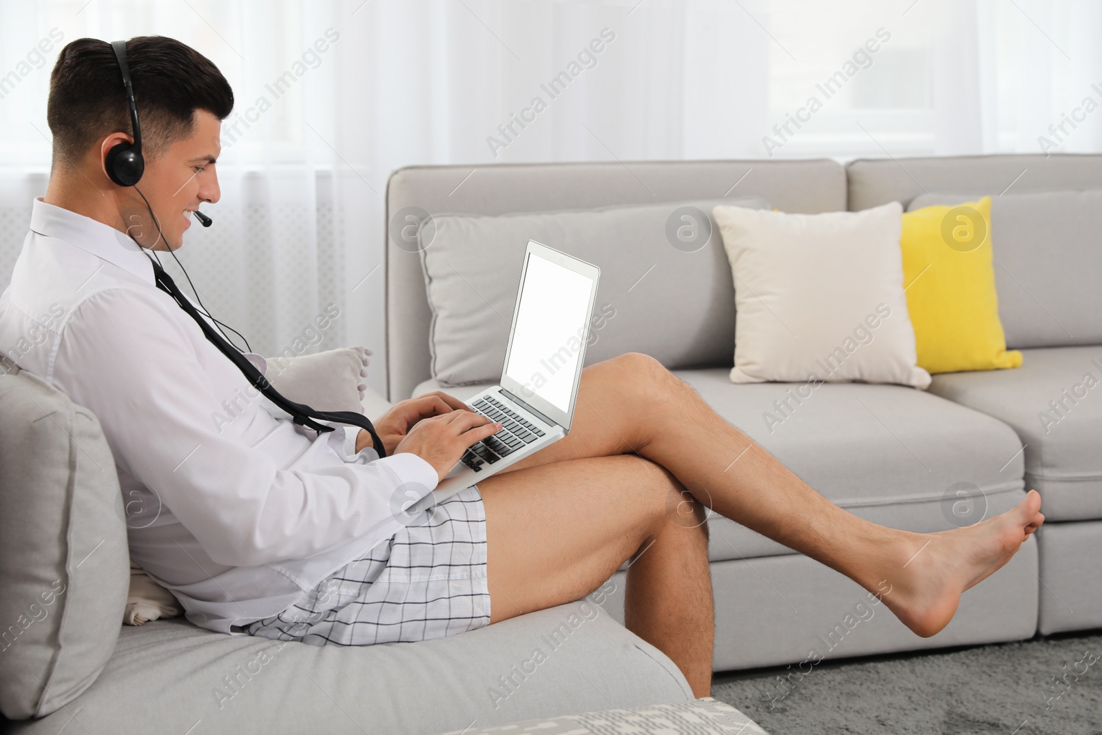 Photo of Man working on laptop in living room. Stay at home concept