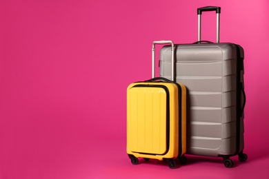 Stylish suitcases on color background. Space for text