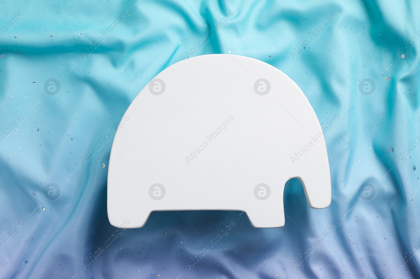 Photo of Animal shaped child's night lamp on color fabric, top view