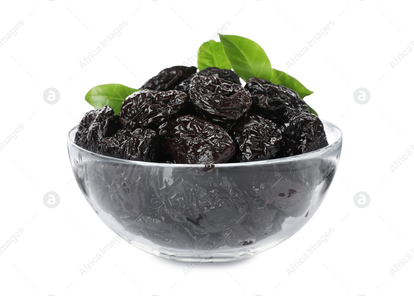 Photo of Bowl with sweet dried prunes and green leaves isolated on white