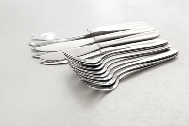 Knives and forks on white table, closeup