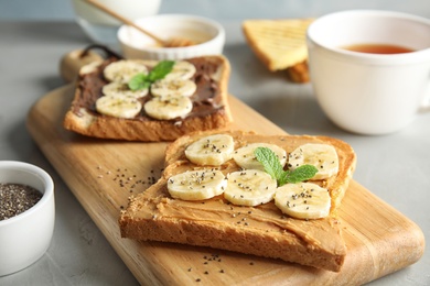 Tasty toasts with banana, mint and chia seeds on wooden board