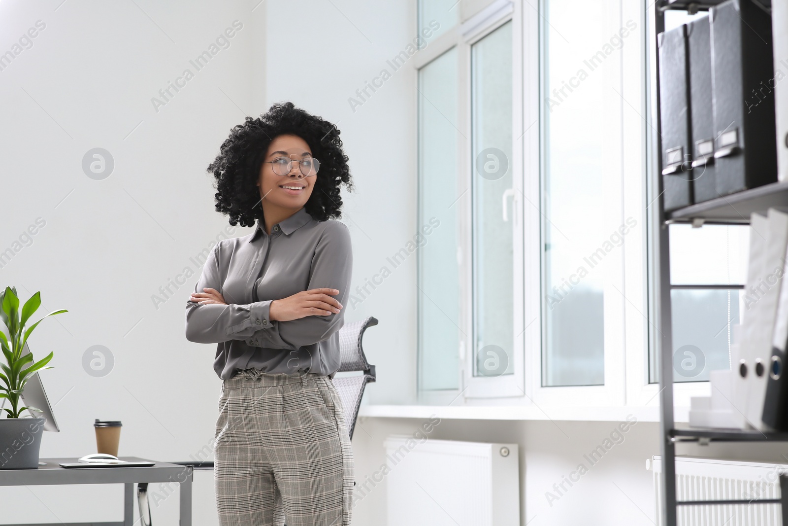 Photo of Smiling young businesswoman in modern office. Space for text