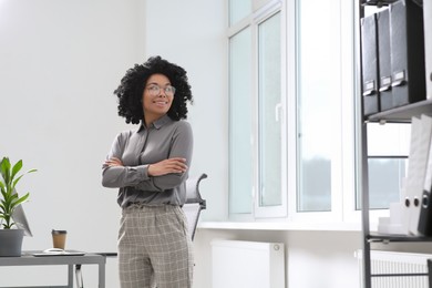 Photo of Smiling young businesswoman in modern office. Space for text