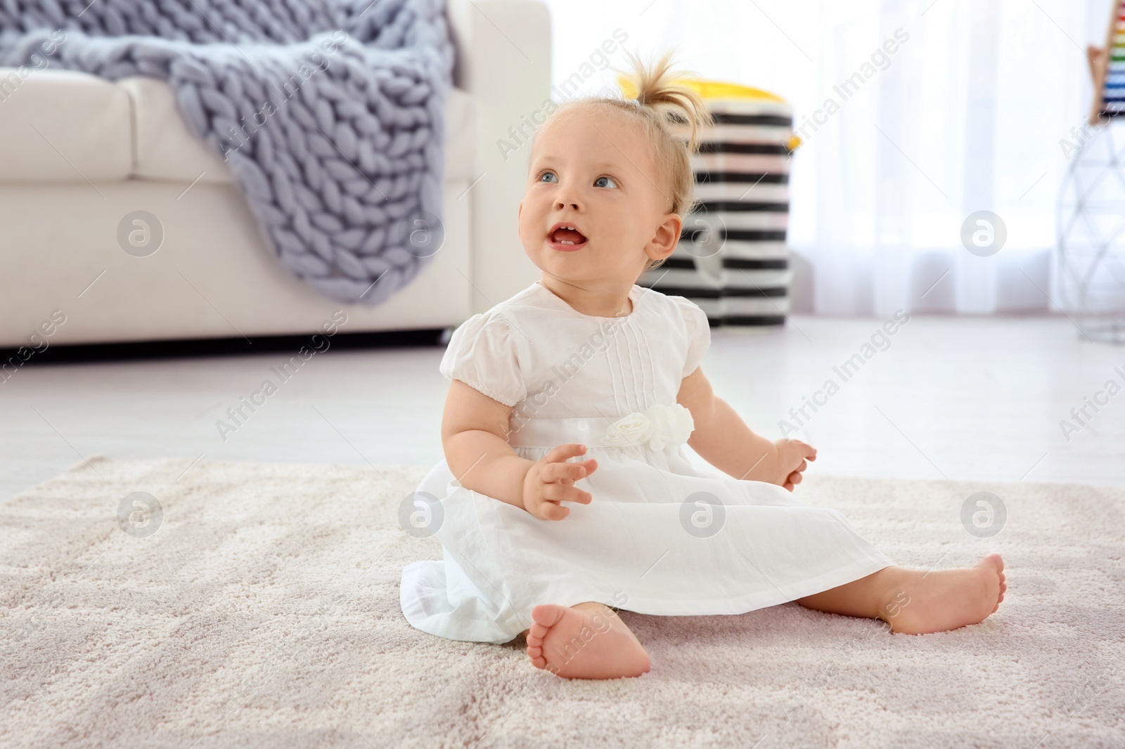 Photo of Adorable baby girl in cute clothes at home