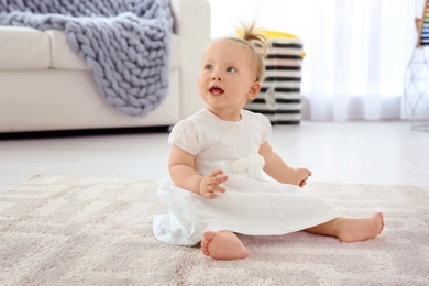 Photo of Adorable baby girl in cute clothes at home