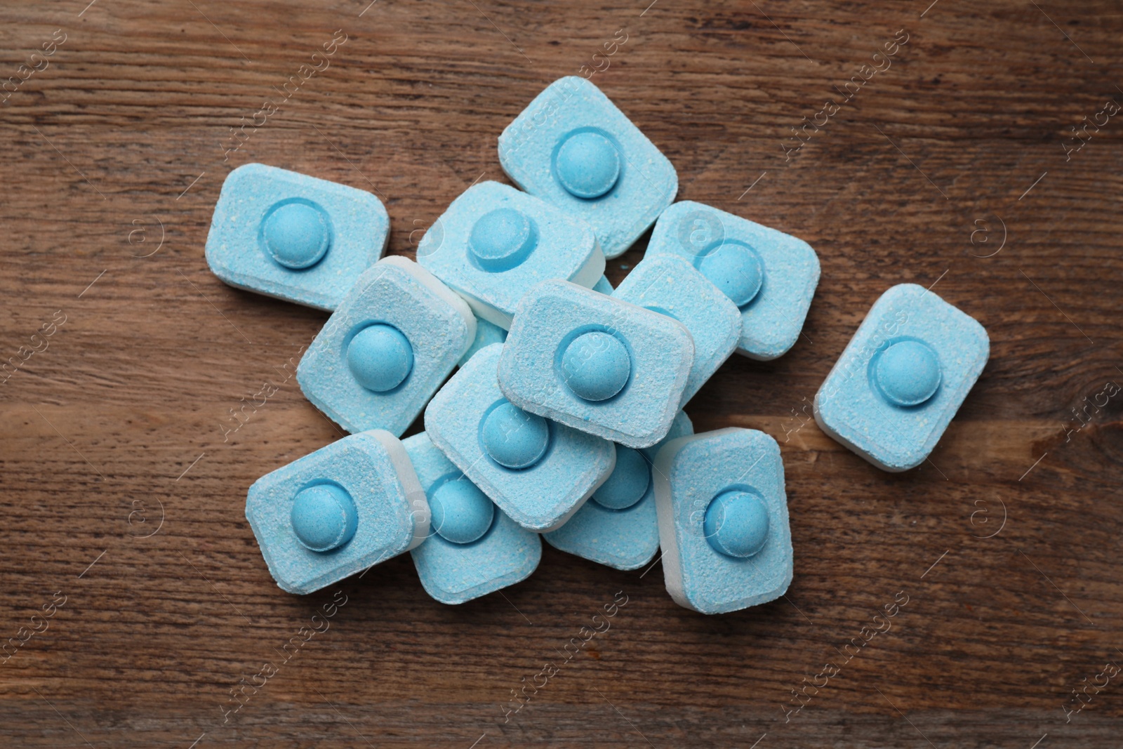 Photo of Water softener tablets on wooden table, flat lay