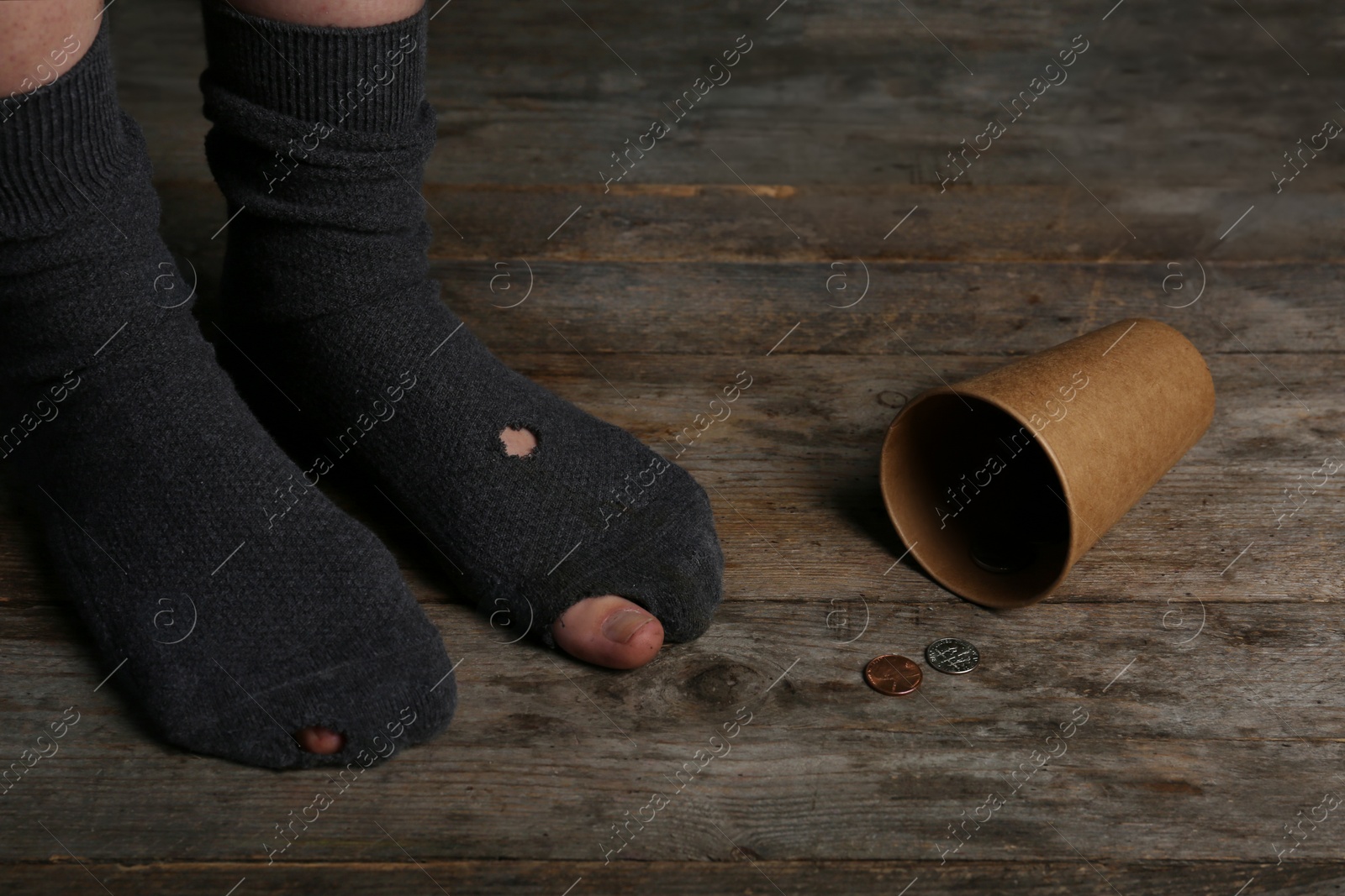 Photo of Poor person in shabby socks begging for money, closeup