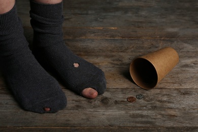 Poor person in shabby socks begging for money, closeup