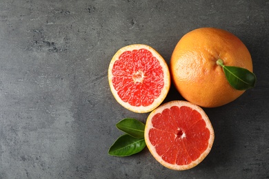 Fresh tasty grapefruits on grey background, top view with space for text