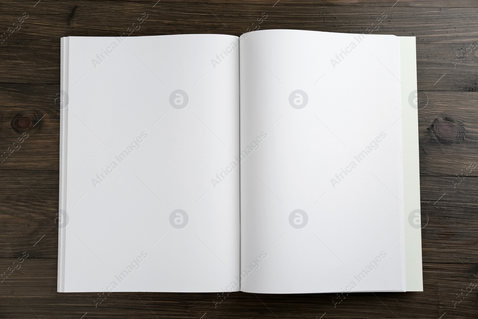 Photo of Open blank paper brochure on wooden table, top view. Mockup for design