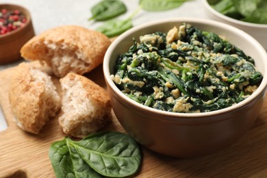 Photo of Tasty spinach dip with egg and bread on table, closeup