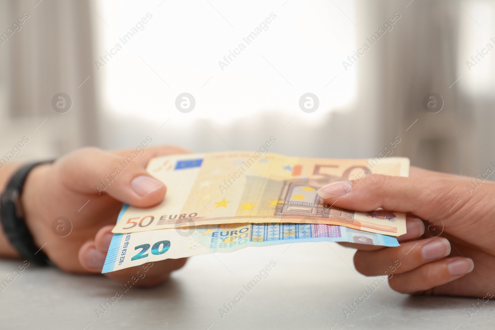 Photo of People with Euro banknotes at table indoors, closeup