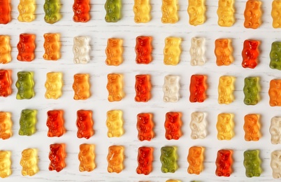 Flat lay composition with delicious color jelly bears on wooden table