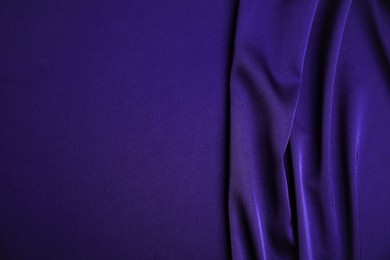 Crumpled purple silk fabric as background, top view. Space for text