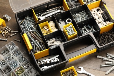 Photo of Organizers with many different fasteners and wrenches on wooden table, above view