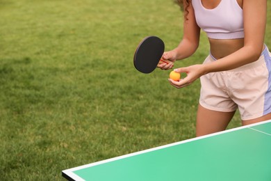 African-American woman playing ping pong outdoors, closeup