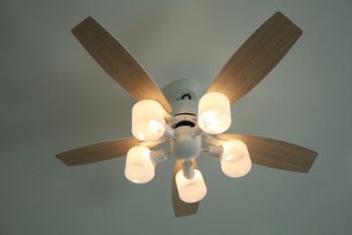 Ceiling fan with lamps indoors, low angle view