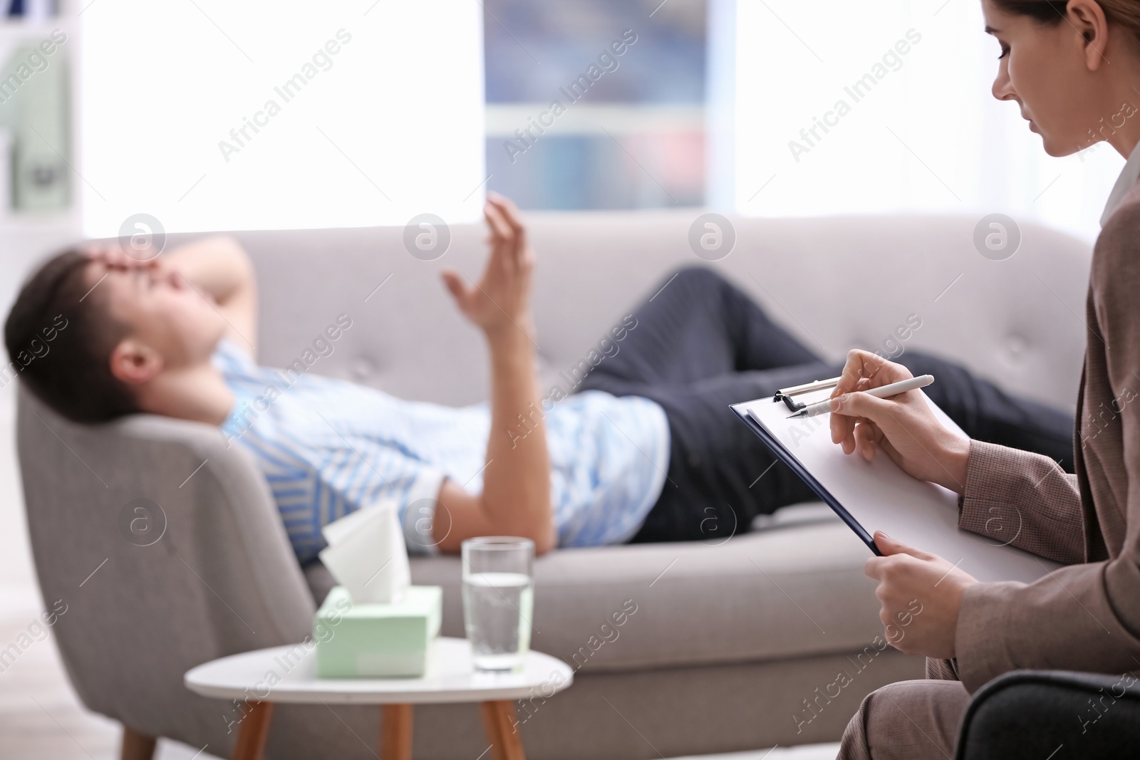 Photo of Psychotherapist working with young man in office