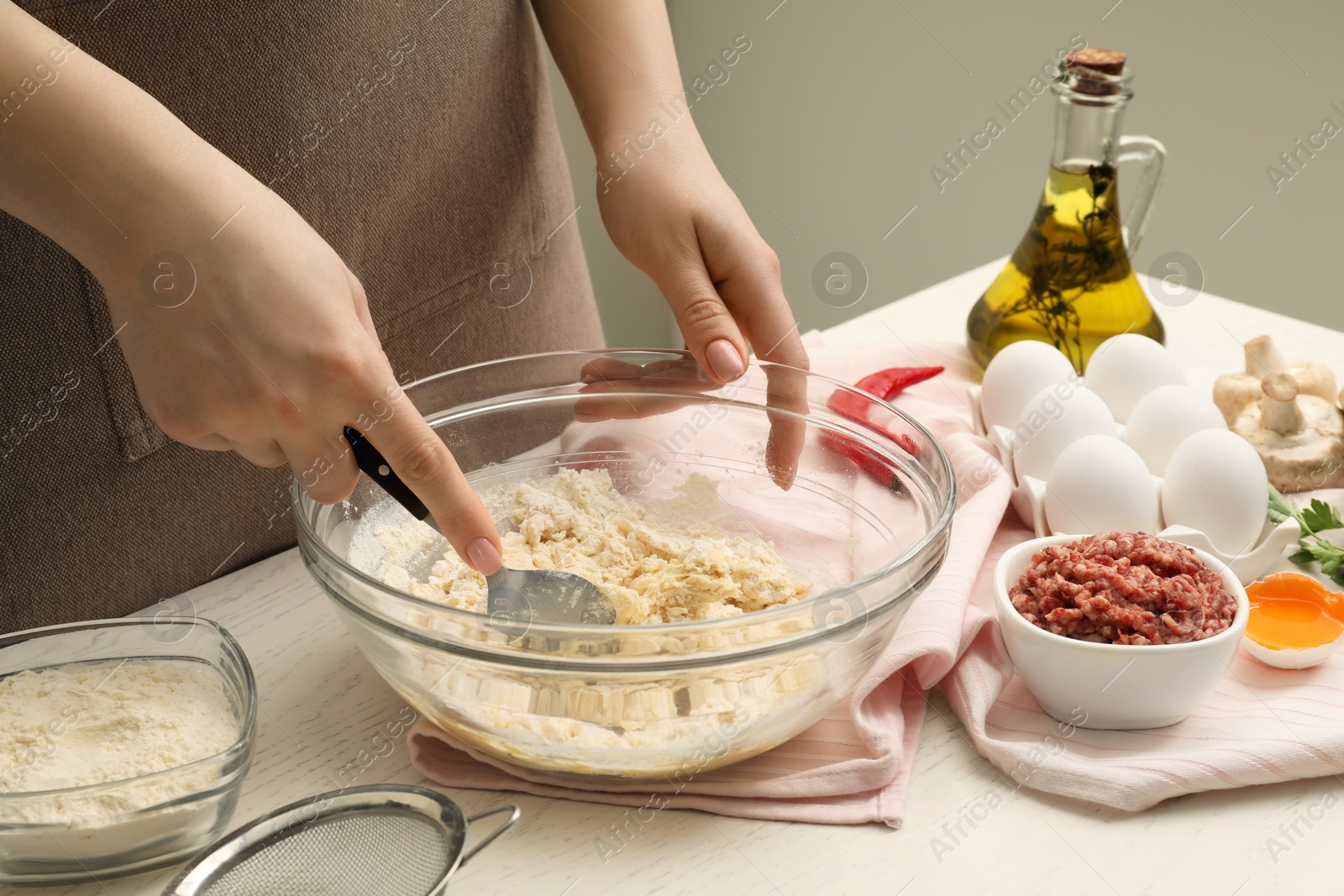 Photo of Woman making dough at white wooden table, closeup