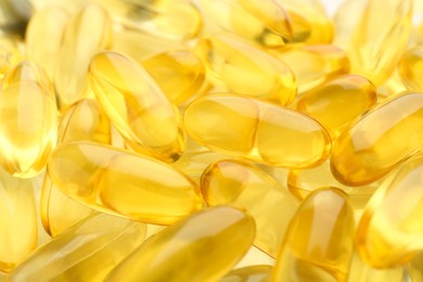 Photo of Many yellow vitamin capsules as background, closeup