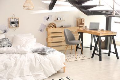 Photo of Elegant interior of bedroom with workplace under stairs