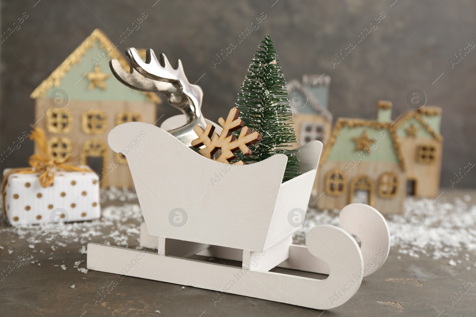 Photo of Beautiful Christmas composition with miniature sleigh on grey table