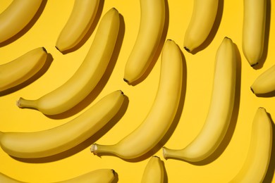 Ripe sweet bananas on yellow background, flat lay