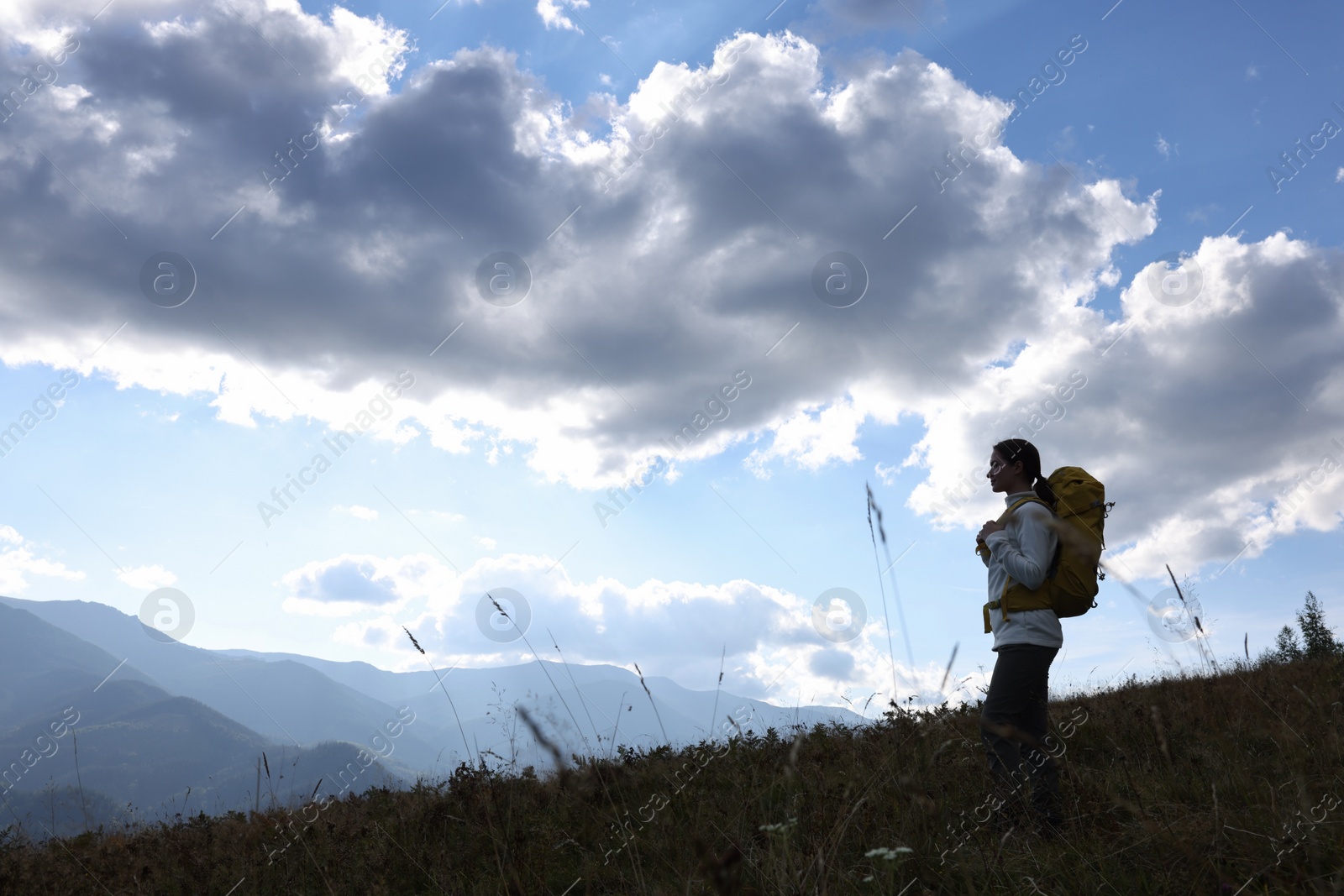 Photo of Tourist with backpack enjoying mountain landscape. Space for text